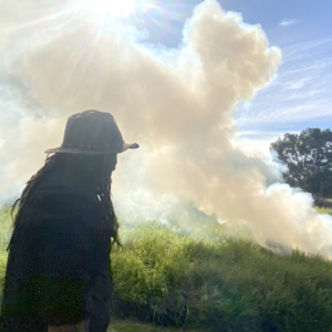 Man on the left watching a plume of white smoke.