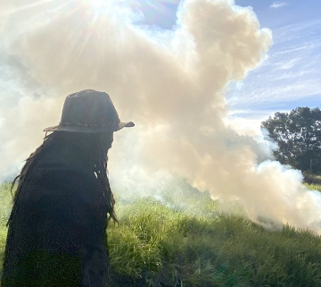 Man on the left watching a plume of white smoke.