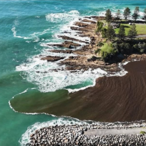 Aerial image of muddy water running into the ocean.