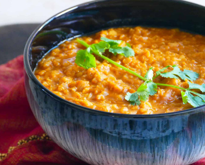 Blue bowl of lentils with coriander on top