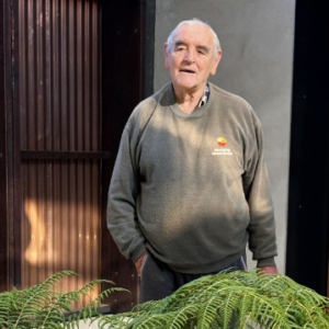 Man standing with a fern in the foreground