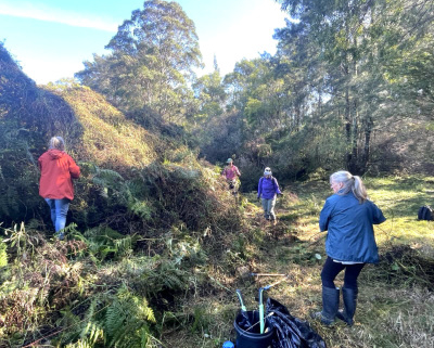 Four people in the Australian bush with tools in the foreground.