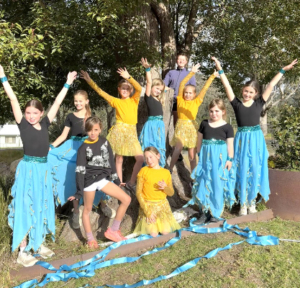 Group of students in bright turquoise costument.