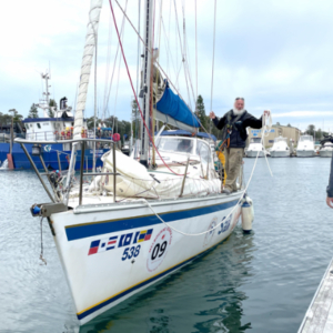 Sailboat in the harbour next to a pier.