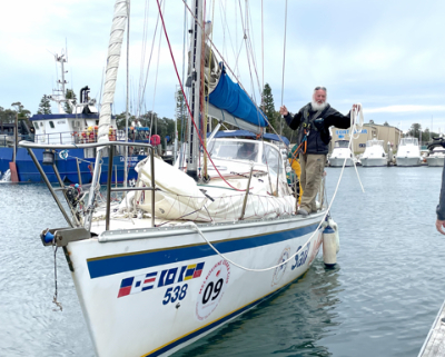 Sailboat in the harbour next to a pier.