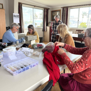 People sewing around a large table.