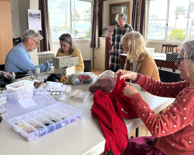 People sewing around a large table.