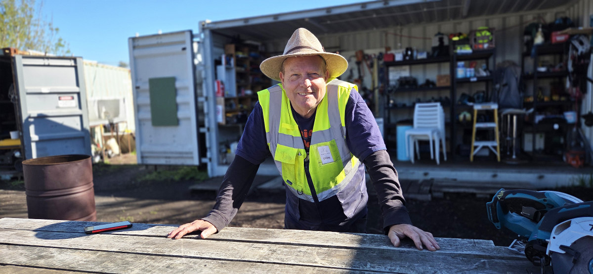 Man in front of an open tool shed