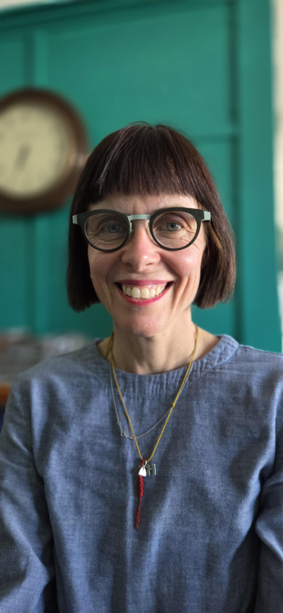 Honor Northam with a bright turquoise wall and a clock in the background.