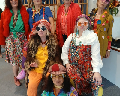 A group of women in wildly colourful costumes and sunglasses