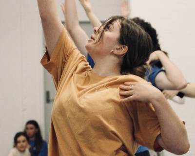 Several women with arms outstretched.