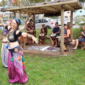 Woman doing belly dancing with drummers in the background