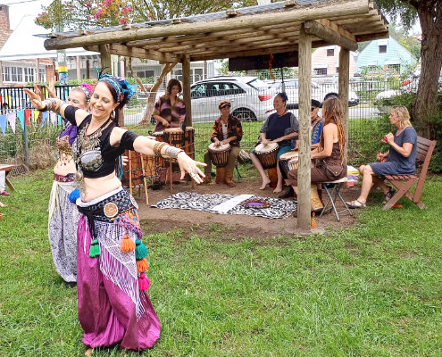 Woman doing belly dancing with drummers in the background