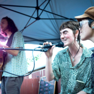 Three people in a band, two singing and one on guitar