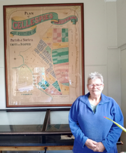 Woman standing in front of a large display of a 1890s map.