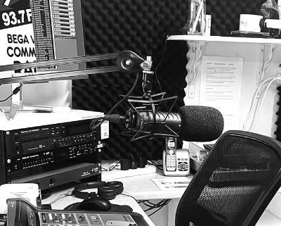 B&W photo of the inside of a radio studio with the mixing deck in the foreground.