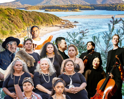 Photo of musicians with their instruments with the shoreline and mountain in the background.