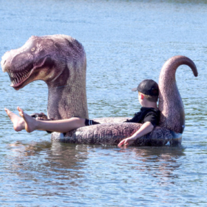 Man in an inflatable T-Rex boat