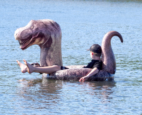 Man in an inflatable T-Rex boat