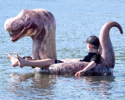 Person floating in a T-Rex inflated boat.