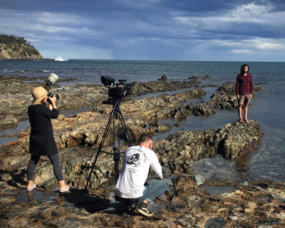 Men filming on a rocky beach