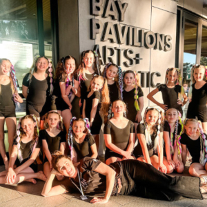 Grop of girls in front a building with the words 'Bay Pavilion' visible.