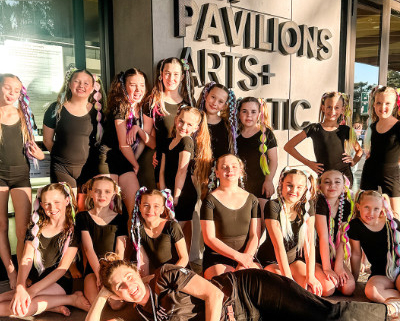 Grop of girls in front a building with the words 'Bay Pavilion' visible.