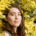 Woman surrounded by yellow wattle flowers.