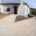 The back entrance to a bulding painted white showing new concrete path for wheelchair access.