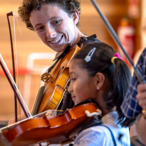 Two people playing violins