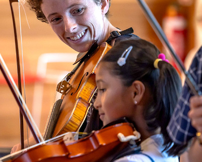 Two people playing violins