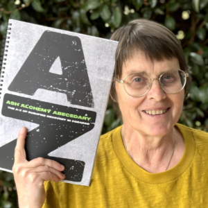 Woman holding a book with very large letters AZ on the cover.