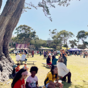 Large open space with people and marquees in the background