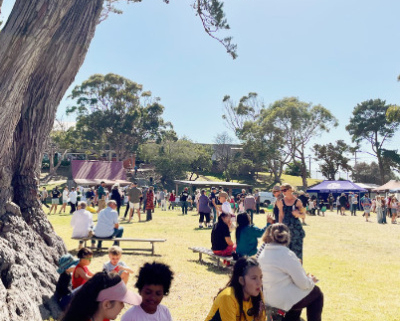 Large open space with people and marquees in the background